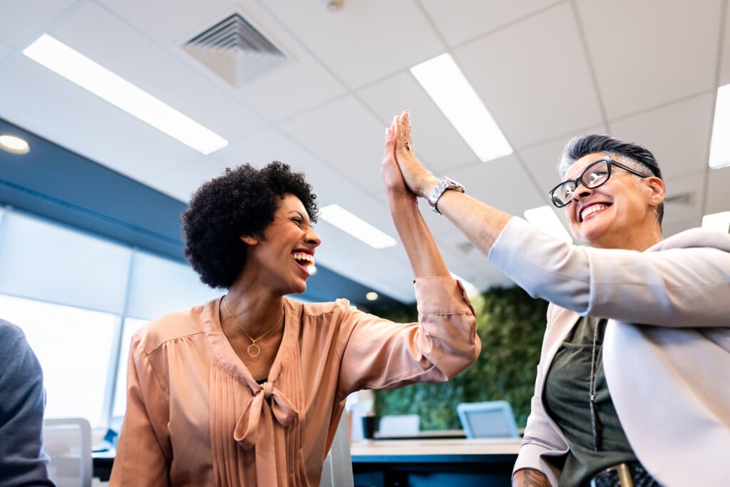 Coworkers doing high-five on the office