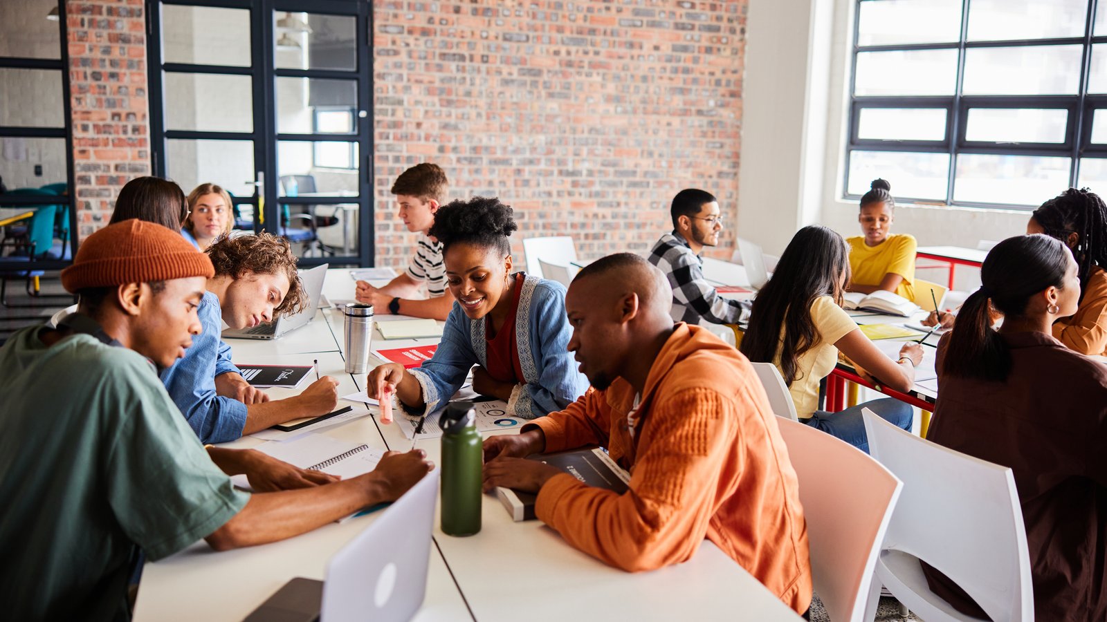 Group of diverse students studying together while sitting around a table 