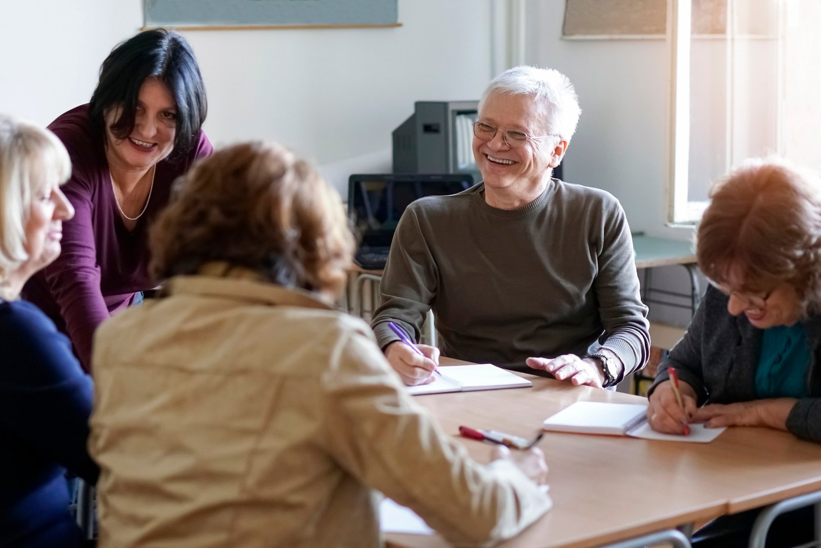 Teacher talking with adult students during a classes.