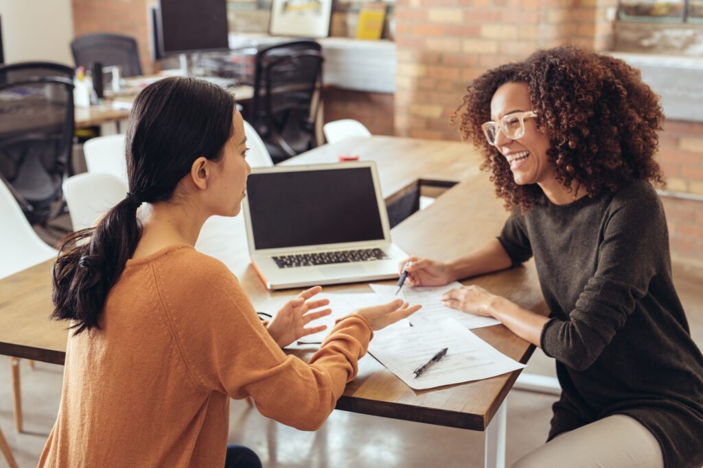 Two women working together at a table.